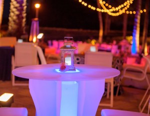 Glowing hightop with steel hurricane lantern with Cafe Lighting in background